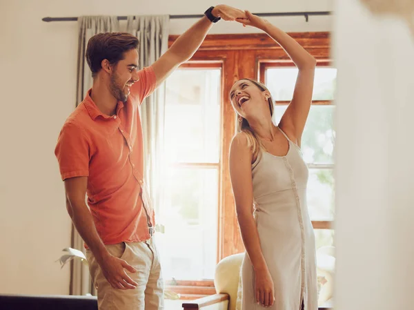a young couple dancing together at home.