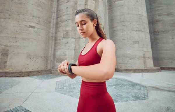 Attractive Young Female Athlete Checking Her Watch While Running Outdoors —  Fotos de Stock