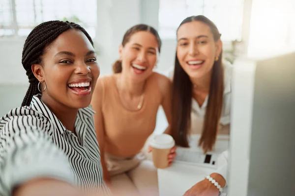 Portrait of a confident young african american business woman taking selfies with her colleagues in an office. Group of three happy smiling women taking photos as a dedicated and ambitious team in a