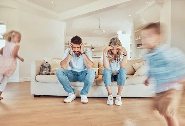 Young Caucasian Parents Suffering Headache While Children Run Lounge Home — Stock Photo, Image