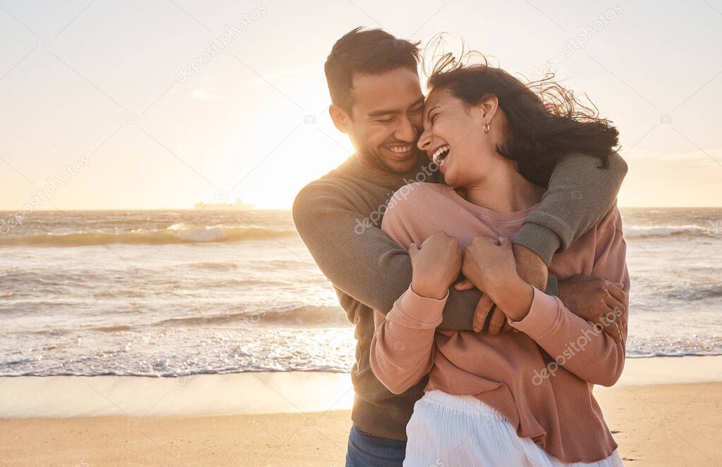 Young diverse biracial couple having fun at the beach together.