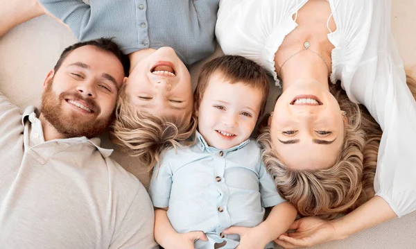 Portrait Smiling Caucasian Family Four Lying Relaxing Floor Home Faces — 스톡 사진