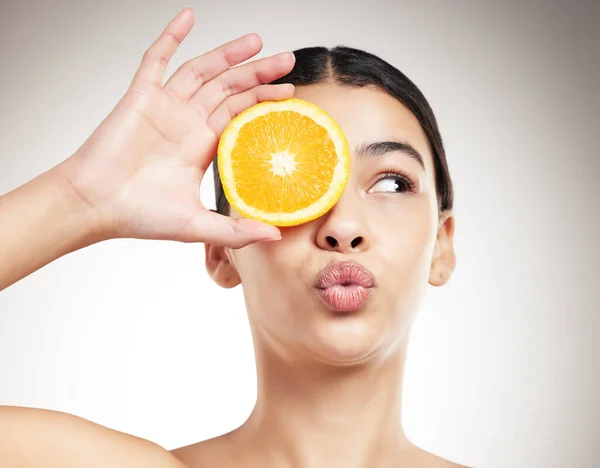 Young Happy Mixed Race Woman Pouting While Holding Orange Posing — стоковое фото