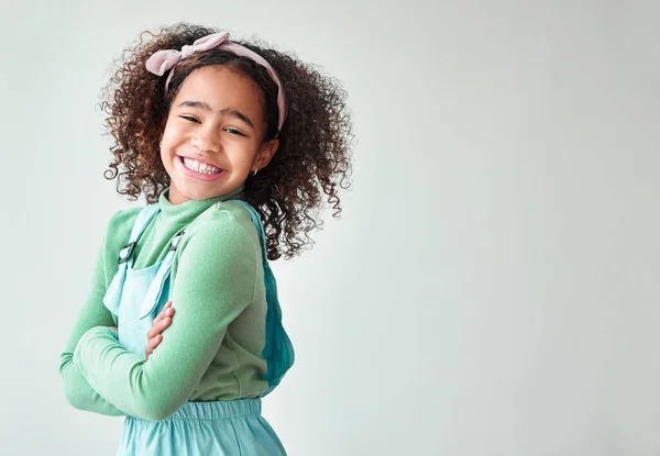 Little girls dance their way into your heart. a little girl standing with crossed arms against a grey background