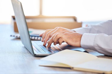 Dizüstü bilgisayarda daktilo eden erkek ellerinin yakın çekimi. İşadamı e-posta yazmak için dizüstü bilgisayar kullanıyor ya da masa başında otururken online araştırma yapıyor.