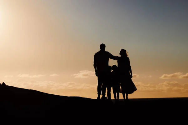 Silhouette Paar Mit Kleinen Kindern Die Draußen Bei Sonnenuntergang Stehen — Stockfoto