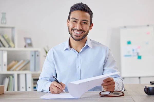 Mixed race cheerful Businessman executive writing notes on paper . Male Hispanic financial advisor smiling and sitting in a office at a startup business.