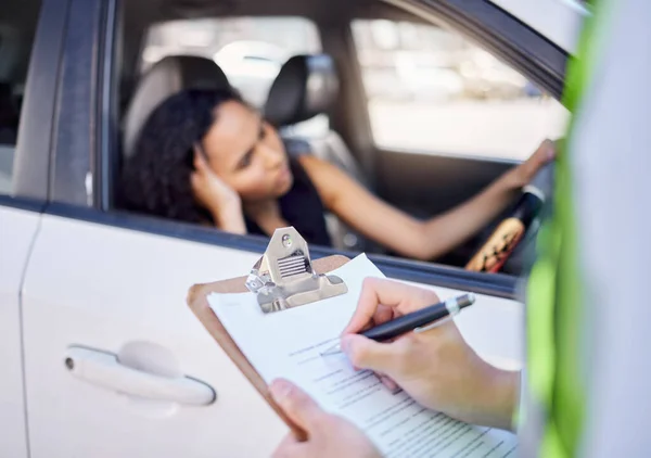 Closeup shot of a traffic officer issuing a woman with a ticket.