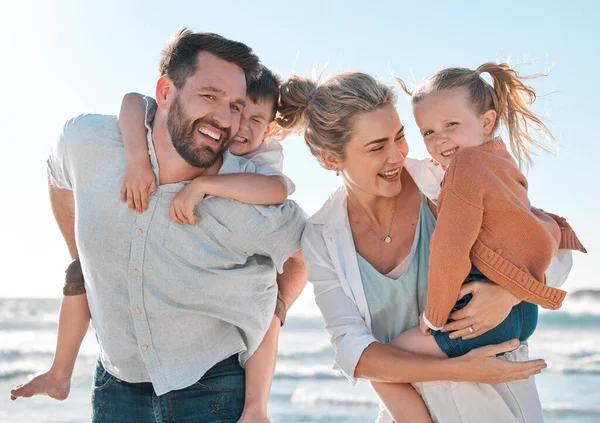 Happy family having fun at the beach. Portrait of smiling parents with children playing and laughing during a summer holiday. Big toothy smiles showing good dental hygiene and health.