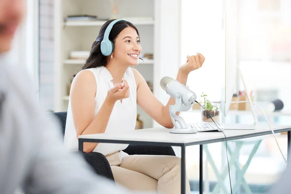 Tune in again next time for more. a young woman using a microphone during a broadcast in an office