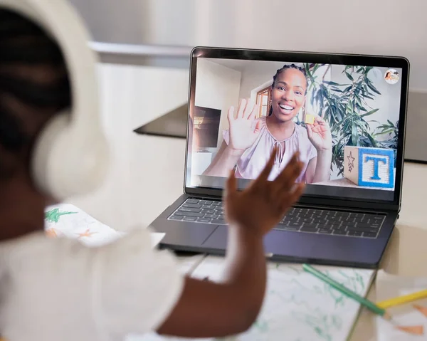 Distance learning with zoom. African american female teacher on a laptop screen home schooling a young girl remotely. Black woman tutor giving a lesson over the internet using wireless headphone tech.