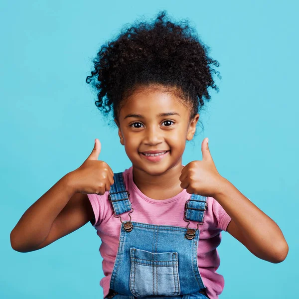 Adorable Little Girl Showing Thumbs While Standing Blue Background — Stockfoto
