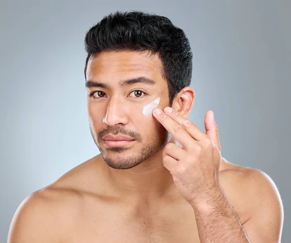 Man Applying Moisturiser His Face While Standing Grey Background — 图库照片