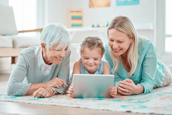 Adorable Little Girl Using Digital Tablet While Lying Home Her — Fotografia de Stock