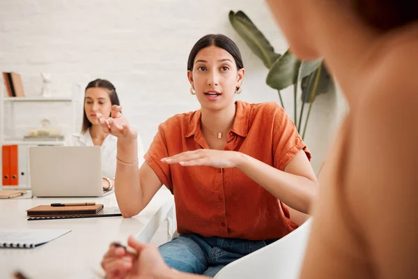 Young hispanic business woman speaking to colleagues during a meeting in an office boardroom. Staff sharing feedback and explaining ideas while brainstorming in a creative startup agency.