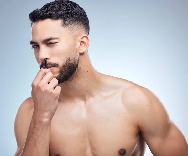 Young Man Tweezing His Nose Hairs Studio Background — Stockfoto