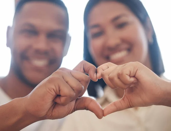 Closeup of mixed race couple making heart shape with hands. Two lovers showing heart sign by joining fingers. Shape of love.