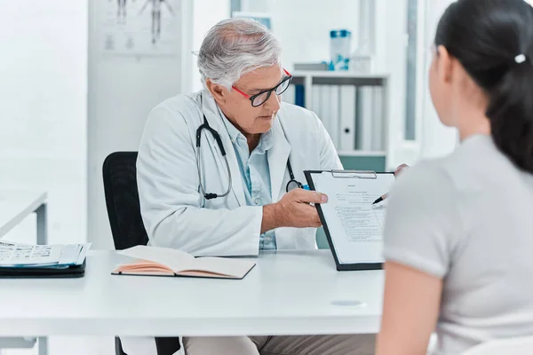 Need You Fill Out Mature Doctor Sitting His Patient Showing — Foto Stock