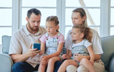 Do you want to send it. a young family using a phone together at home
