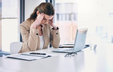 I need a miracle to make it through today. a young businesswoman looking stressed out while working on a computer in an office