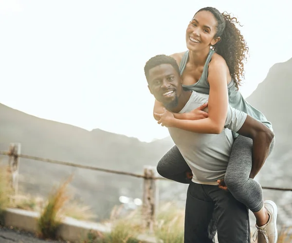 A strong back makes for a strong friendship. a young man giving his girlfriend a piggyback ride