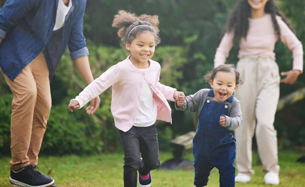 Play is our brains favourite way of learning. two adorable little girls having fun with their family outdoors