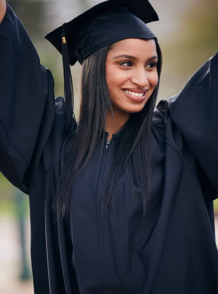 Graduated and loving it. a young woman cheering on graduation day