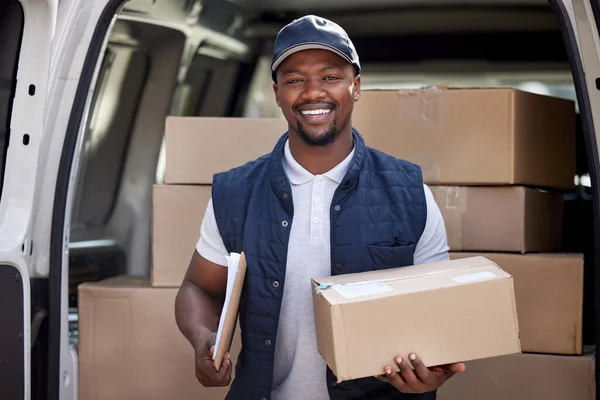 Delivering happiness and goods. a delivery man standing by his van