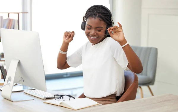 Take time for yourself too. a young businesswoman listening to music at work