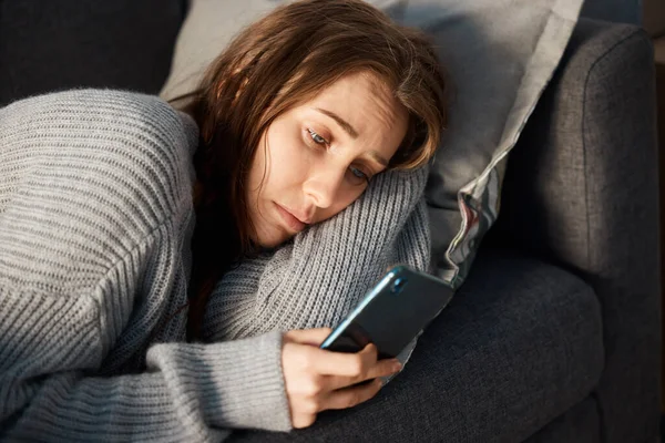 Eine Junge Frau Sieht Deprimiert Aus Während Sie Ihr Smartphone — Stockfoto