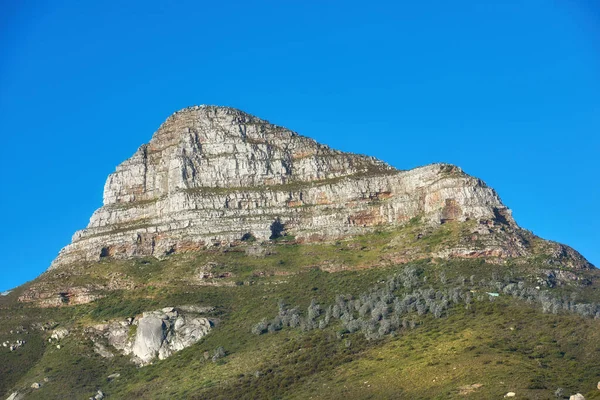 Beautiful Lions Head mountain on clear blue sky with copy space. Summer landscape of mountains with hills covered in green grass or bushes at a tourism sightseeing location in Cape Town, South Africa.