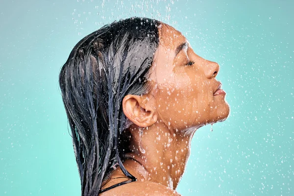 Skin care must be good enough to eat. an attractive young woman showering against a blue background