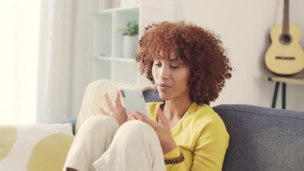 Zaskoczona Kobieta Wyglądająca Zszokowaną Otrzymaniu Dobrych Wiadomości Sms Telefonie Siedząc — Wideo stockowe