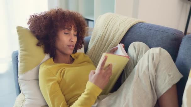 Beautiful Afro Woman Reading Intriguing Book While Relaxing Couch Home — Stockvideo