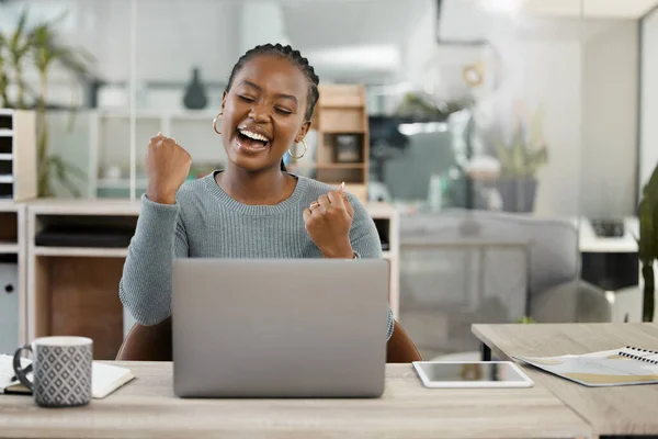 There is no end to the good news. an excited young businesswoman cheering while sitting at her desk