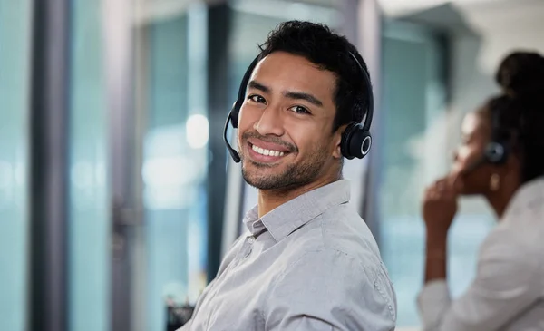 Im ready to help customers today. a handsome young customer service agent sitting in the office and wearing a headset
