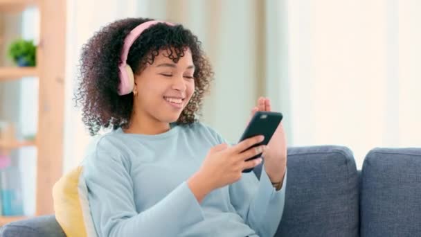 Молода Безтурботна Жінка Слухає Музику Телефоні Сидячи Дивані Своїй Вітальні — стокове відео