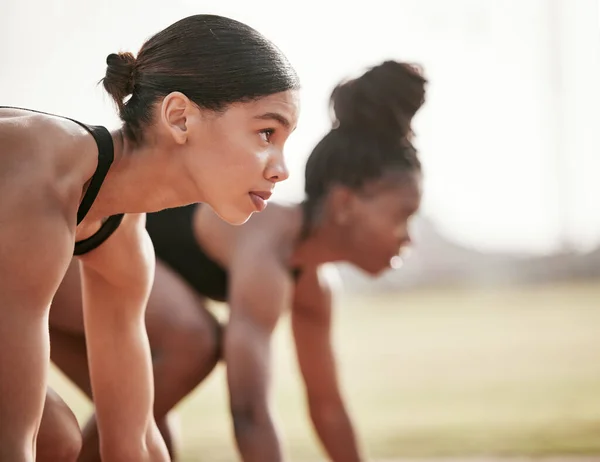 Shes only thinking about winning. two attractive young female athletes starting their race on a track