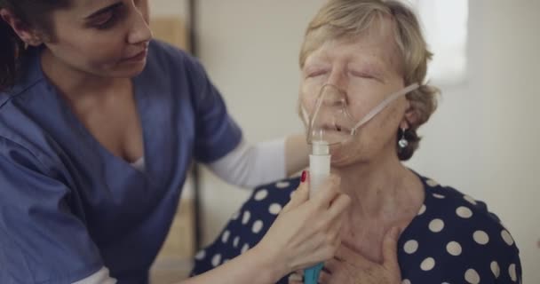 Video Footage Nurse Helping Female Elderly Patient Use Oxygen Mask — Stockvideo