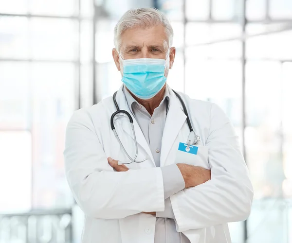 Sometimes I inspire my patients. a medical practitioner standing with his arms crossed in a hospital