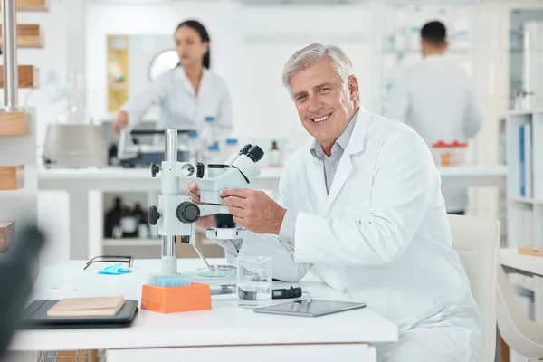 Science is the main tool to explore the hidden secret of world. Portrait of a senior scientist using a microscope in a lab