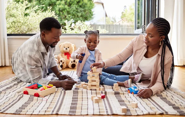 Relationships are nothing without a solid foundation. a little girl playing with blocks with her parents at home