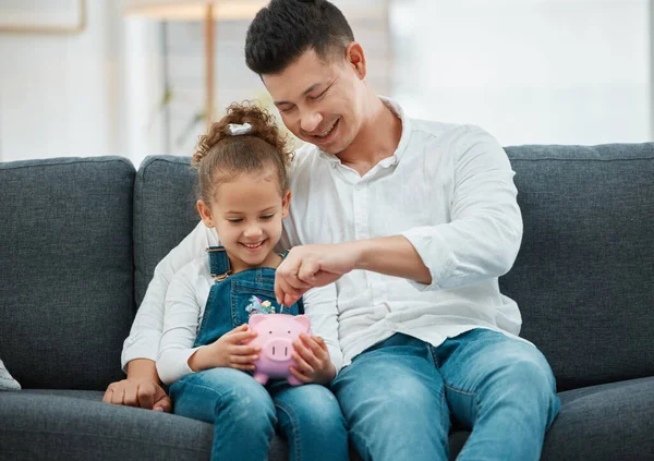 Be smart when investing. a father teaching his daughter to save in a piggybank