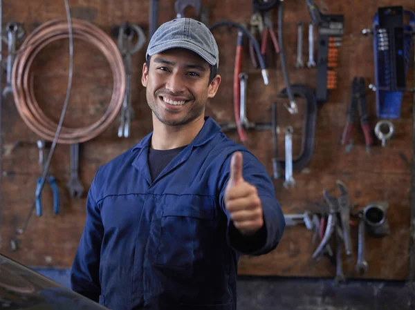 Ive got everything I need to service your vehicle. Cropped portrait of a handsome young male mechanic giving thumbs up towards the camera while in his workshop