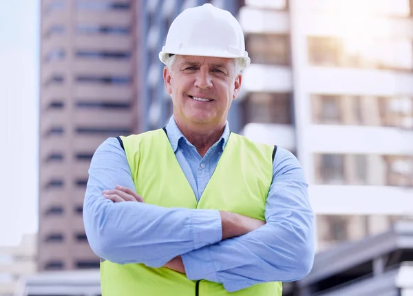 Construction site confidence. Cropped portrait of a handsome mature male construction worker standing with his arms folded outside