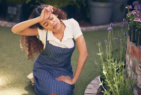 Giving these green thumbs a break. a young florist looking stressed while at work