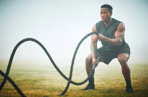When is the last time you amazed yourself. a muscular young man exercising with battle ropes outdoors