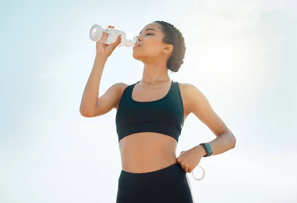 Water breaks are a necessity. a young woman re hydrating during a workout