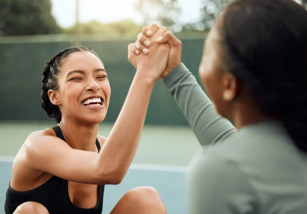 We smashed it today. two attractive young female athletes cheering while exercising outside on a sports court