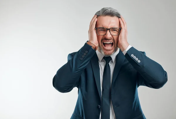 The markets are crashing. Studio portrait of a mature businessman screaming against a white background